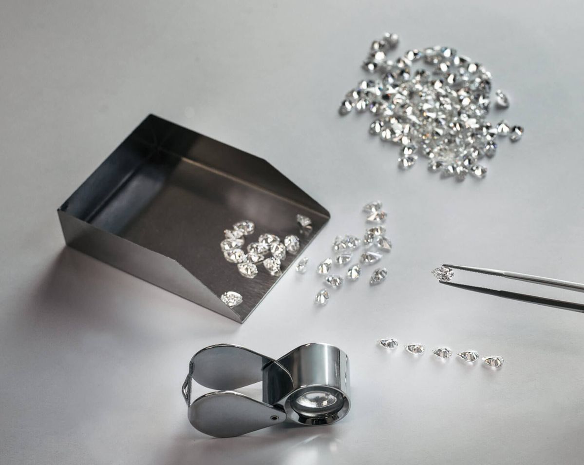 Loose polished diamonds with sorting scoop and loupe
