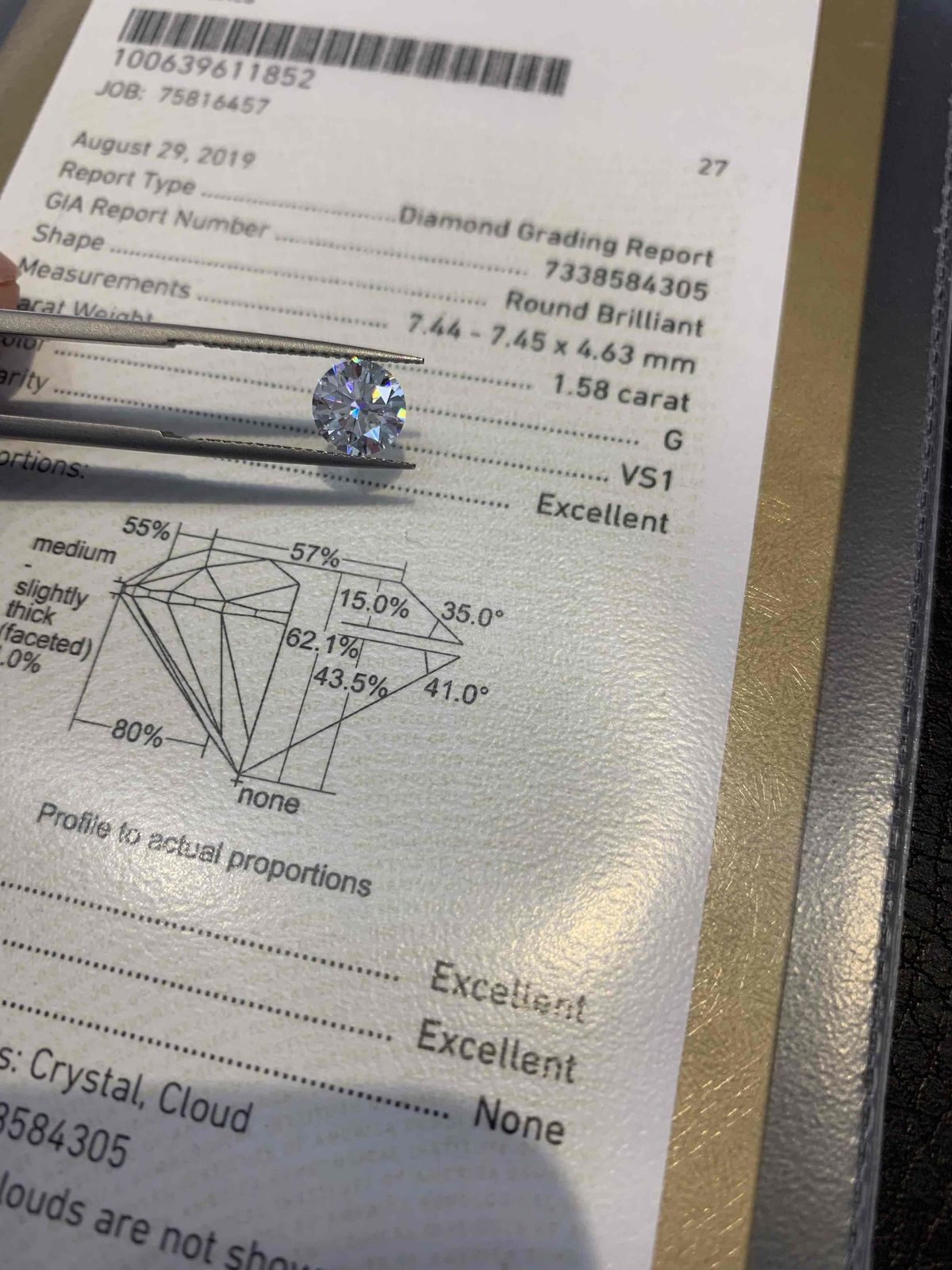 Diamond held over GIA grading report with proportions diagram